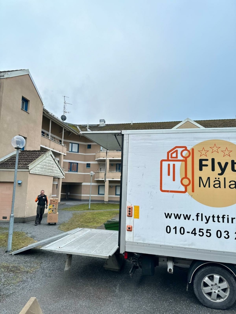 En medarbetare från Flytt och städfix Mälardalen AB avlastar en flyttbil under en flytt.